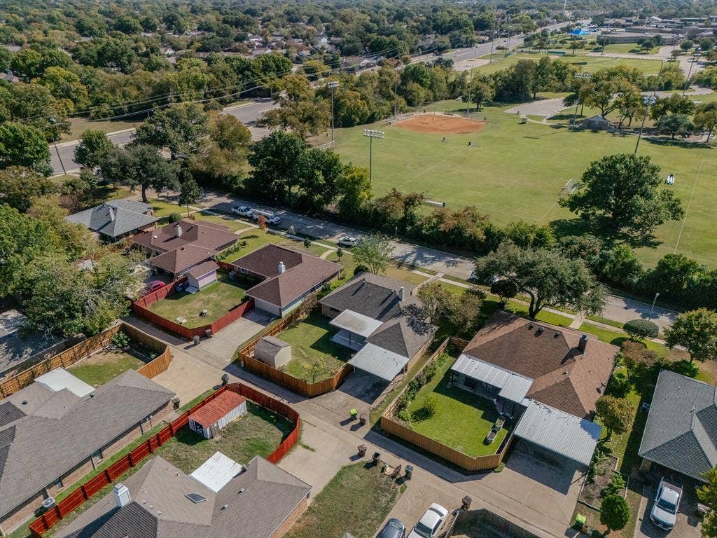 2213 Moore Drive, Plano, TX 75074 Aerial perspective featuring residential lots with fenced perimeters, paved driveways, and covered parking structures