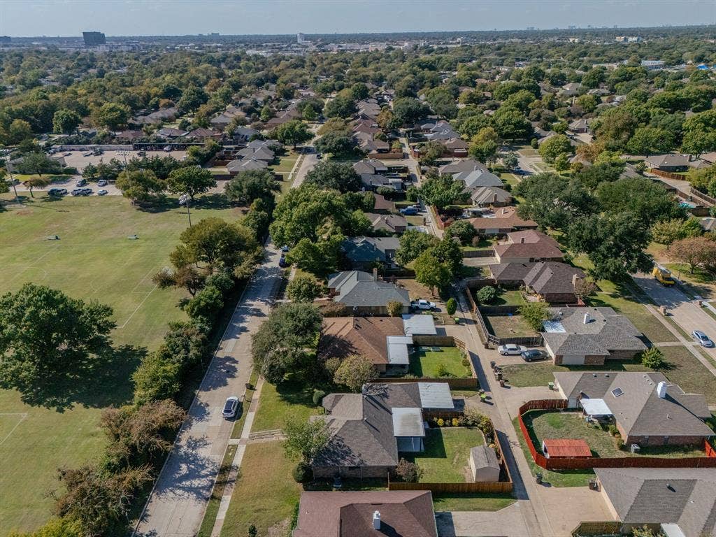 2213 Moore Drive, Plano, TX 75074 Aerial perspective of a residential neighborhood featuring established tree canopy, grass-covered open space, and suburban street grid