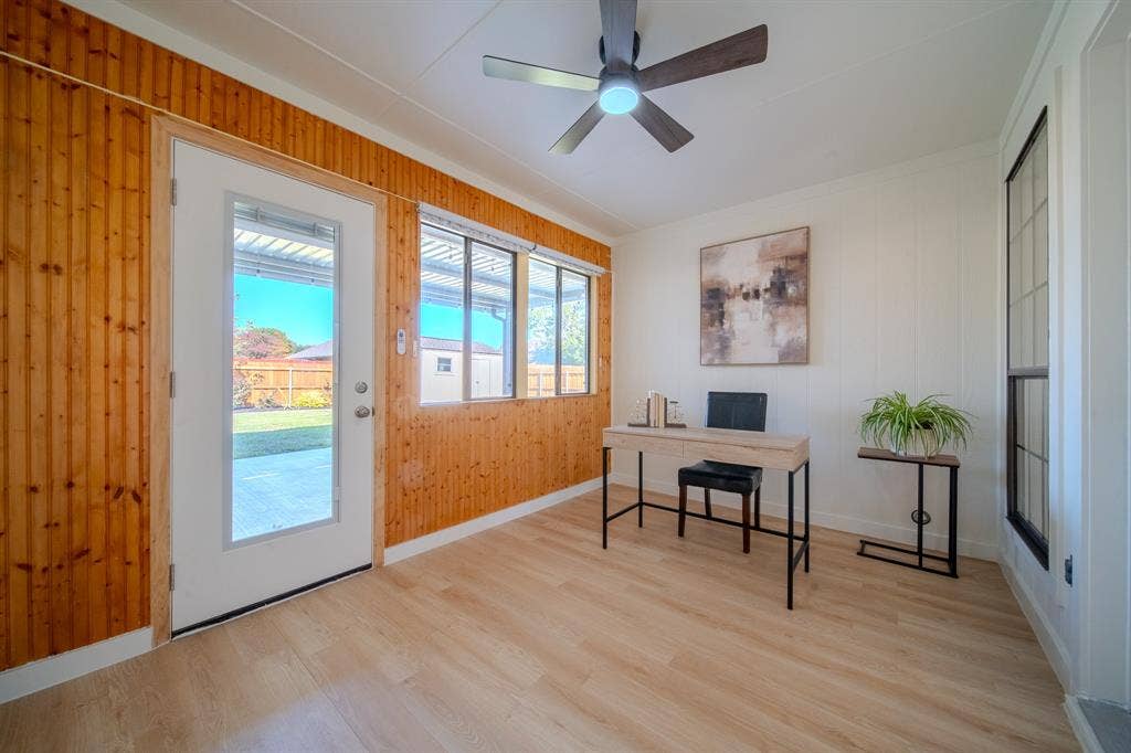 2213 Moore Drive, Plano, TX 75074 Natural wood-paneled walls, light wood-finish flooring, multi-pane windows, full-lite exterior door, and ceiling fan with integrated lighting
