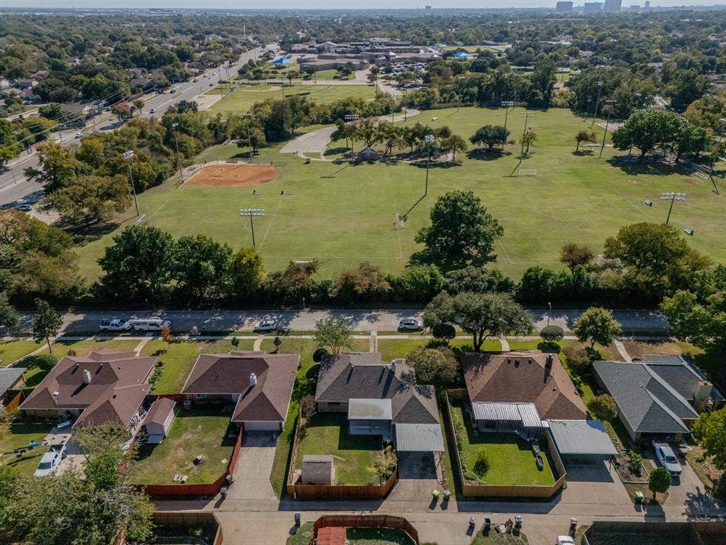 2213 Moore Drive, Plano, TX 75074 Aerial perspective of residential properties featuring shingle roofing, attached garages, and fenced rear yards
