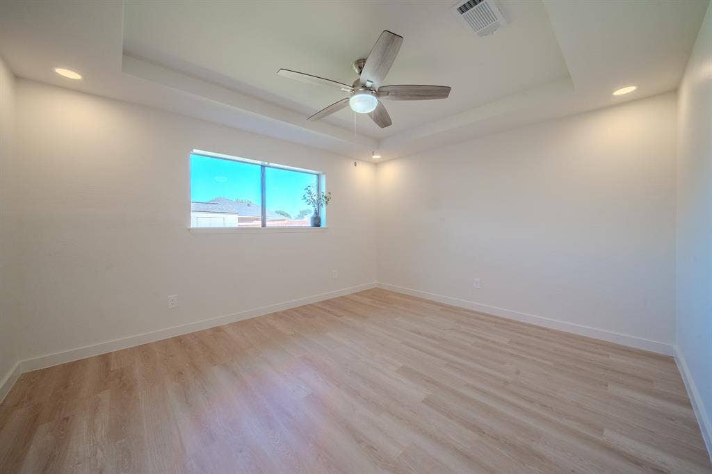 2213 Moore Drive, Plano, TX 75074 Tray ceiling featuring recessed lighting and a central ceiling fan, complemented by wood-finish flooring