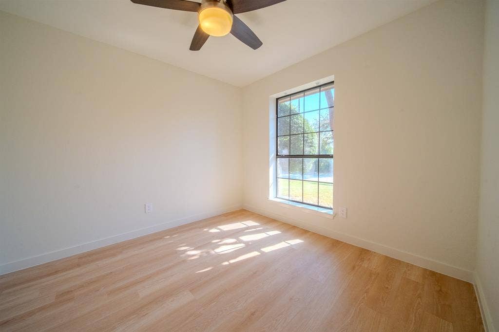 2213 Moore Drive, Plano, TX 75074 Room featuring wood-finish flooring, a multi-pane window, and a ceiling fan with integrated lighting