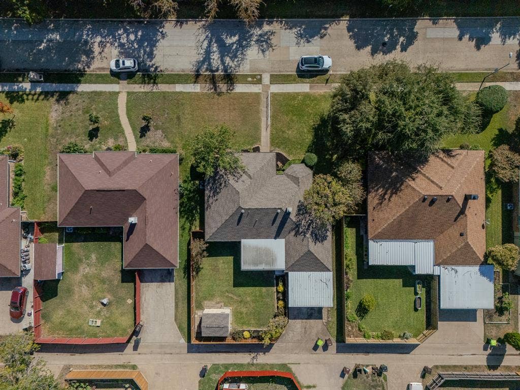 2213 Moore Drive, Plano, TX 75074 Aerial perspective featuring a residential property with a detached storage structure, concrete driveway, and a fenced backyard