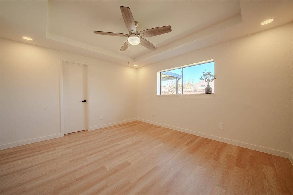2213 Moore Drive, Plano, TX 75074 Tray ceiling room featuring wood-finish flooring, recessed lighting, and a multi-blade ceiling fan with integrated lighting