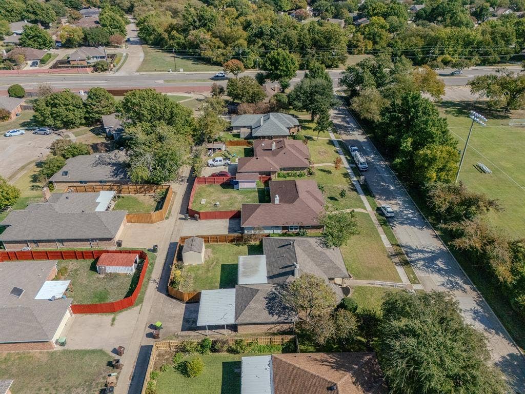 2213 Moore Drive, Plano, TX 75074 Aerial perspective of a residential neighborhood featuring established tree cover, concrete sidewalks, paved street infrastructure, and proximity to expansive open green space