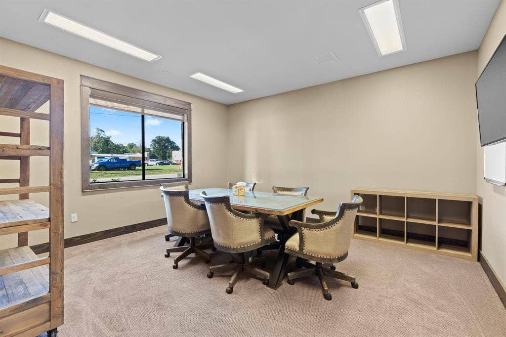 700 N Main Street, Lindale, TX 75771 Multi-purpose room featuring recessed LED panel lighting, neutral carpeting, a large window with dark-finish trim, and built-in cubby shelving