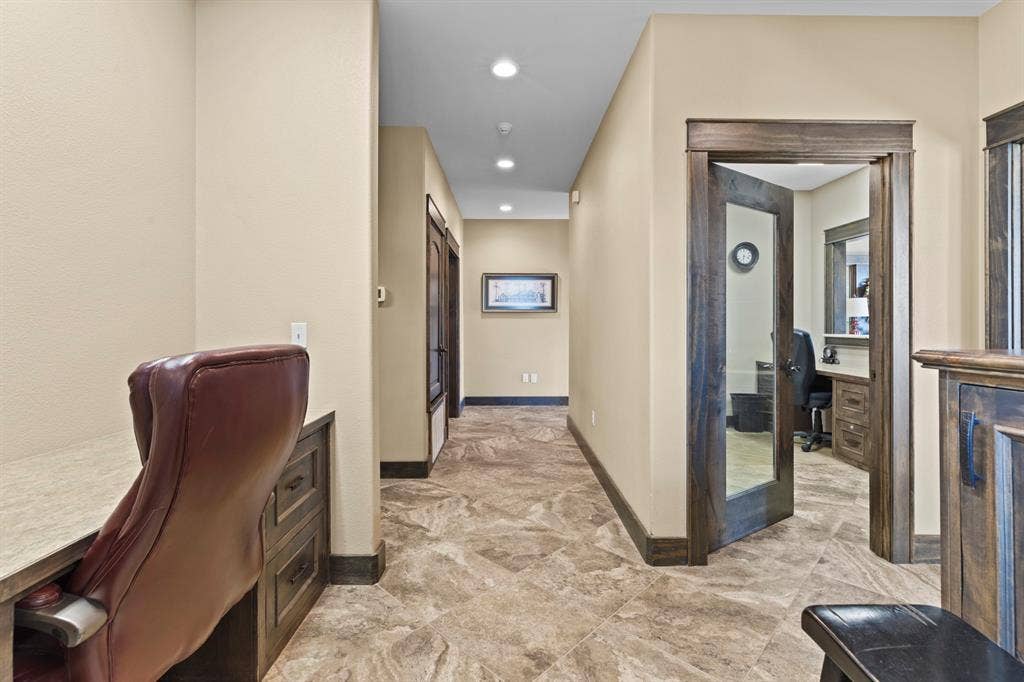 700 N Main Street, Lindale, TX 75771 Hallway featuring stone-tile flooring, recessed lighting, and built-in desk cabinetry with a neutral countertop