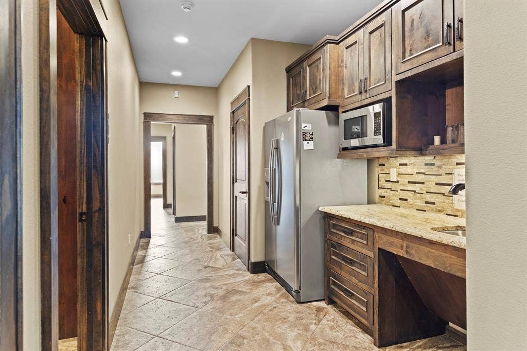 700 N Main Street, Lindale, TX 75771 Custom wood cabinetry, stone-finish countertops, tile flooring, built-in stainless steel microwave, and recessed lighting