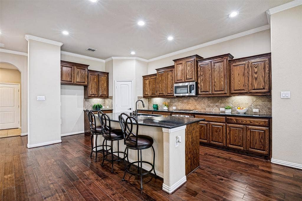 8303 Lake Valley Court, Rowlett, TX 75089 Stunning oversized Kitchen has Great Island, stainless appliances, including gas cooktop.