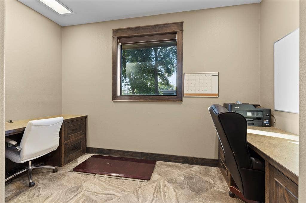 700 N Main Street, Lindale, TX 75771 Custom wood-finish cabinetry with stone-surface countertops, recessed ceiling lighting, and tile flooring featuring natural stone-patterned veining