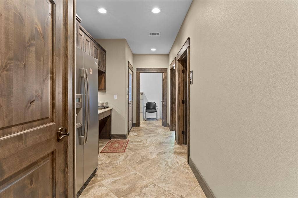 700 N Main Street, Lindale, TX 75771 Stained wood door and door casings, stone-finish tile flooring, recessed ceiling lighting, and built-in cabinetry
