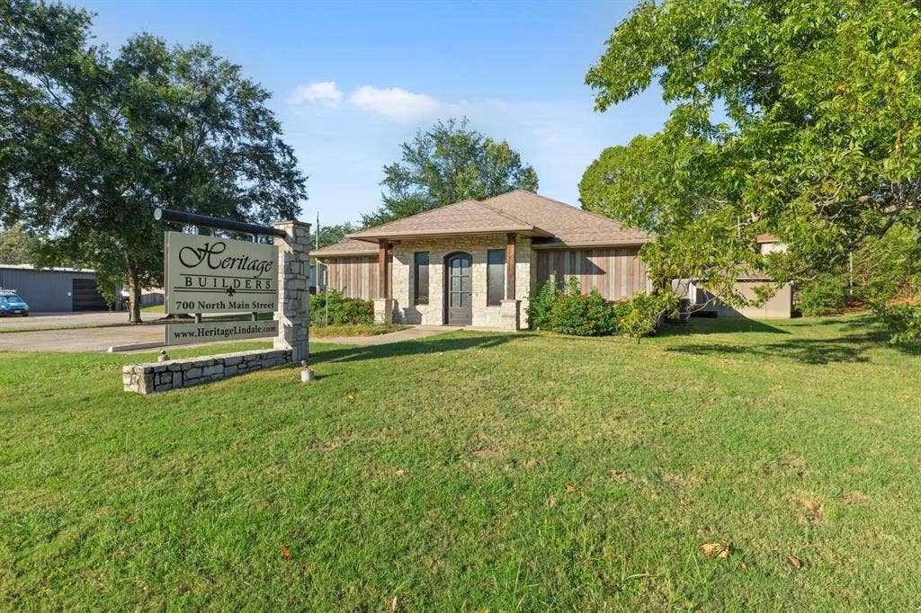700 N Main Street, Lindale, TX 75771 Single-story exterior featuring stone masonry, vertical wood siding, a hip roof, and decorative timber-frame porch accents