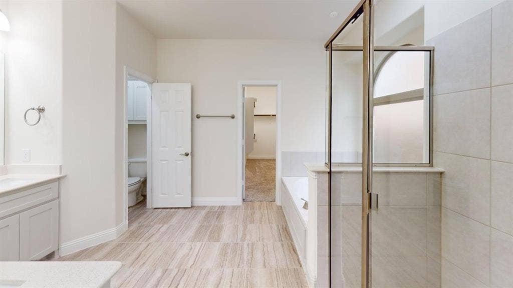 14518 Shady Grove Lane, Frisco, TX 75035 Bathroom featuring tile flooring, a glass-enclosed shower with tiled walls, a deep soaking tub, and a vanity with a stone countertop