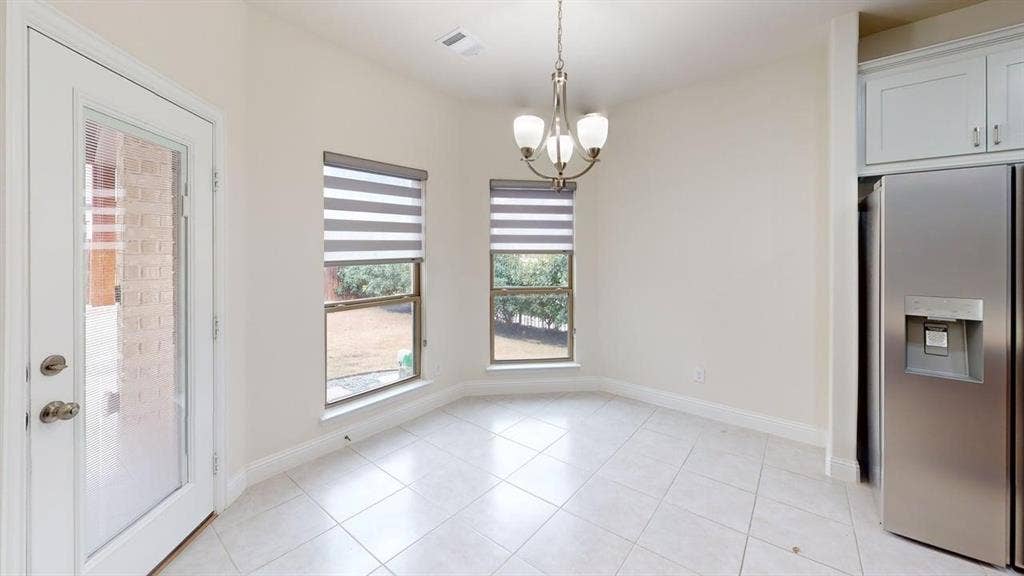 14518 Shady Grove Lane, Frisco, TX 75035 Ceramic tile flooring, neutral wall tones, multi-light chandelier, and large windows with integrated blinds