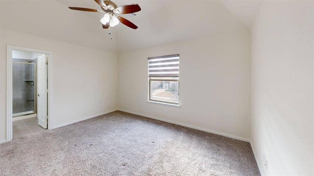 14518 Shady Grove Lane, Frisco, TX 75035 Room featuring a vaulted ceiling, ceiling fan with light fixture, neutral carpeted flooring, and a window with roller shade