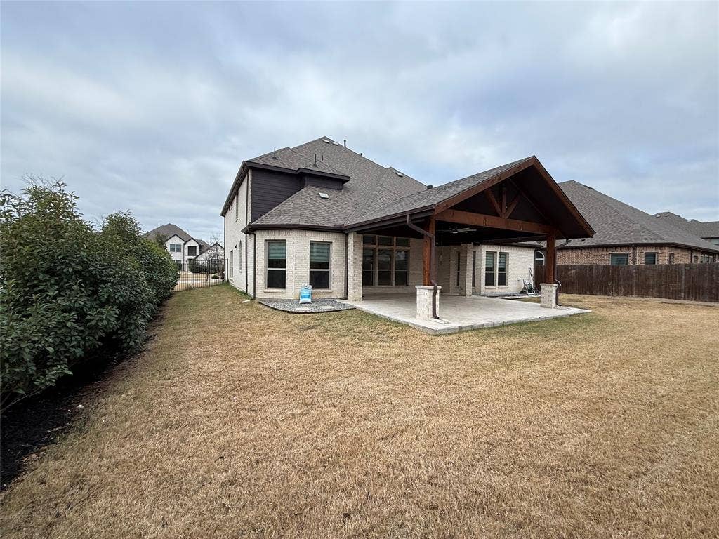 14518 Shady Grove Lane, Frisco, TX 75035 Brick exterior with a stone-accented covered patio, timber-framed roof structure, and perimeter fencing