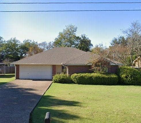 1114 Idlewood Drive, Waco, TX 76705 Single-story residence featuring a brick exterior, attached two-car garage, concrete driveway, and a front lawn with established landscaping