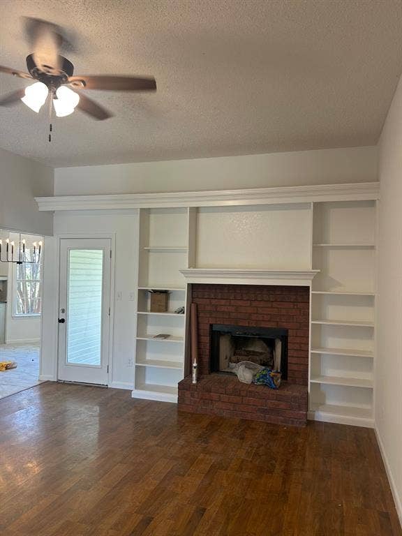 1114 Idlewood Drive, Waco, TX 76705 Brick fireplace with integrated shelving, crown molding, wood-finish flooring, and ceiling fan