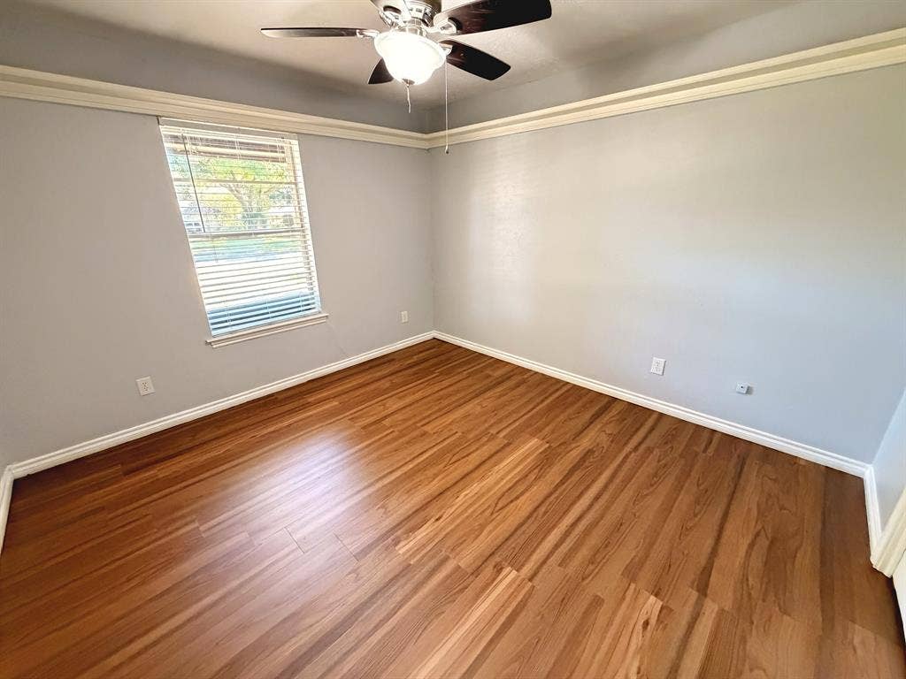 2701 Northcrest Drive, Plano, TX 75075 Room featuring wood-finish flooring, crown molding, a single window with horizontal blinds, and a ceiling fan with integrated lighting