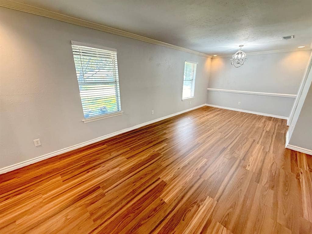 2701 Northcrest Drive, Plano, TX 75075 Wood-finish flooring, crown molding, chair rail, and a decorative orb chandelier