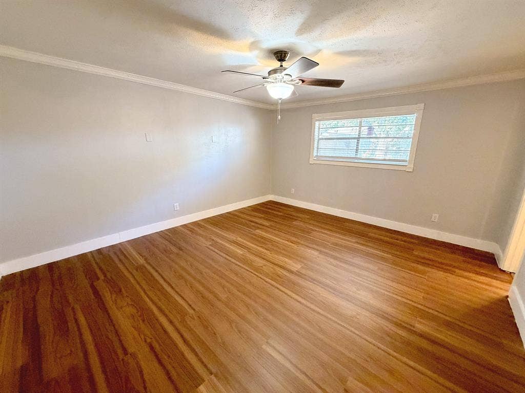 2701 Northcrest Drive, Plano, TX 75075 Room featuring wood-finish flooring, crown molding, and a central ceiling fan with integrated lighting
