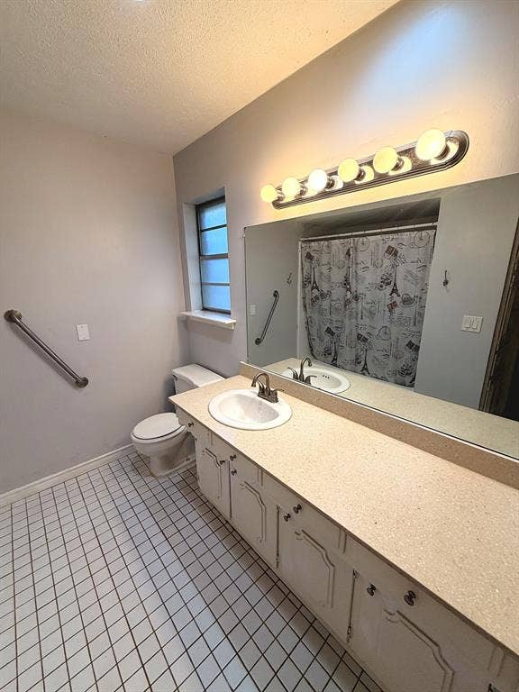 2701 Northcrest Drive, Plano, TX 75075 Bathroom featuring a large vanity with a neutral-tone countertop, an integrated sink, an expansive wall-mounted mirror, and tile flooring