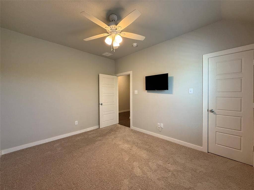 1702 Sagebrush Trail, Wylie, TX 75098 High ceilings, neutral wall tones, plush wall-to-wall carpeting, four-panel interior doors, and a central ceiling fan with integrated lighting