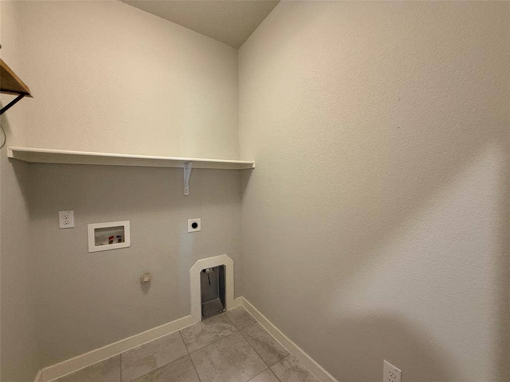 1702 Sagebrush Trail, Wylie, TX 75098 Utility space featuring tile flooring, neutral wall paint, and a mounted upper storage shelf