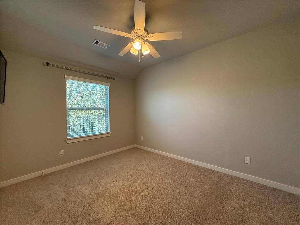 1702 Sagebrush Trail, Wylie, TX 75098 Neutral-toned room featuring a vaulted ceiling, neutral wall-to-wall carpeting, and a multi-blade ceiling fan with an integrated light fixture