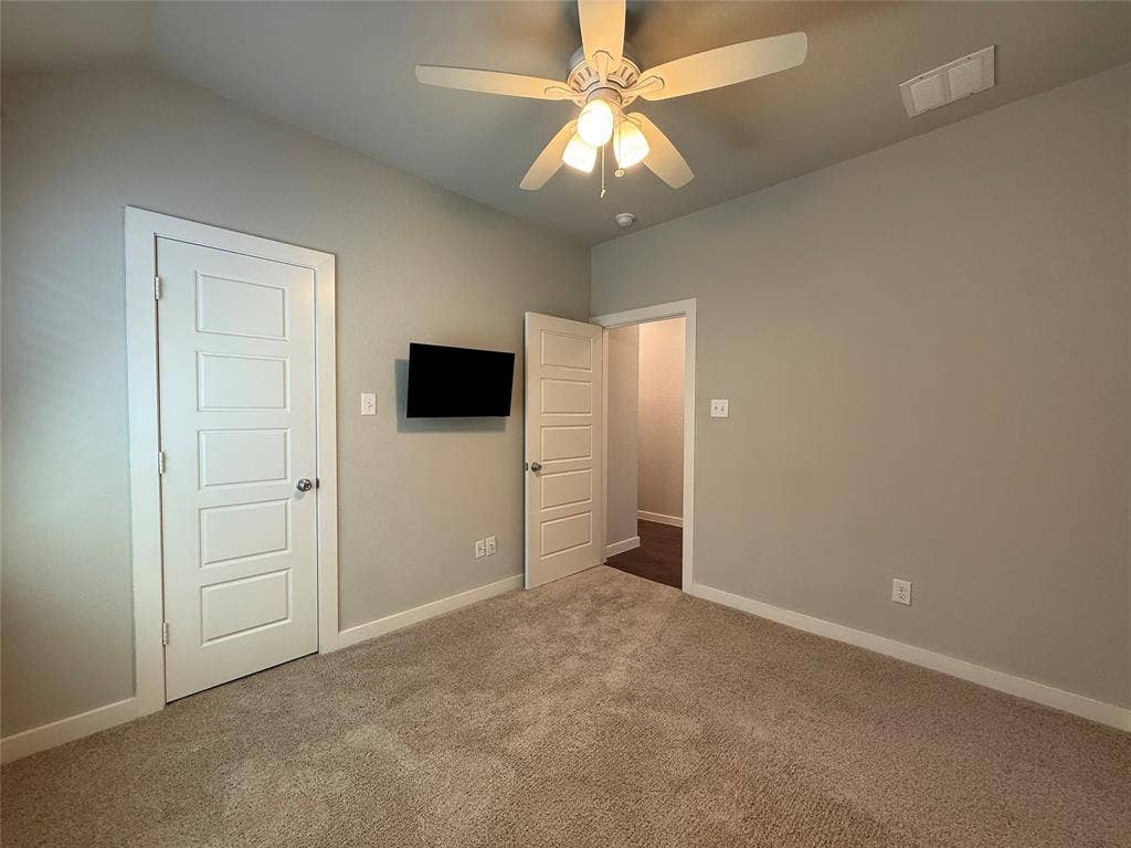 1702 Sagebrush Trail, Wylie, TX 75098 Neutral-toned interior featuring wall-to-wall carpeting, five-panel interior doors, and a ceiling-mounted light fixture with a fan