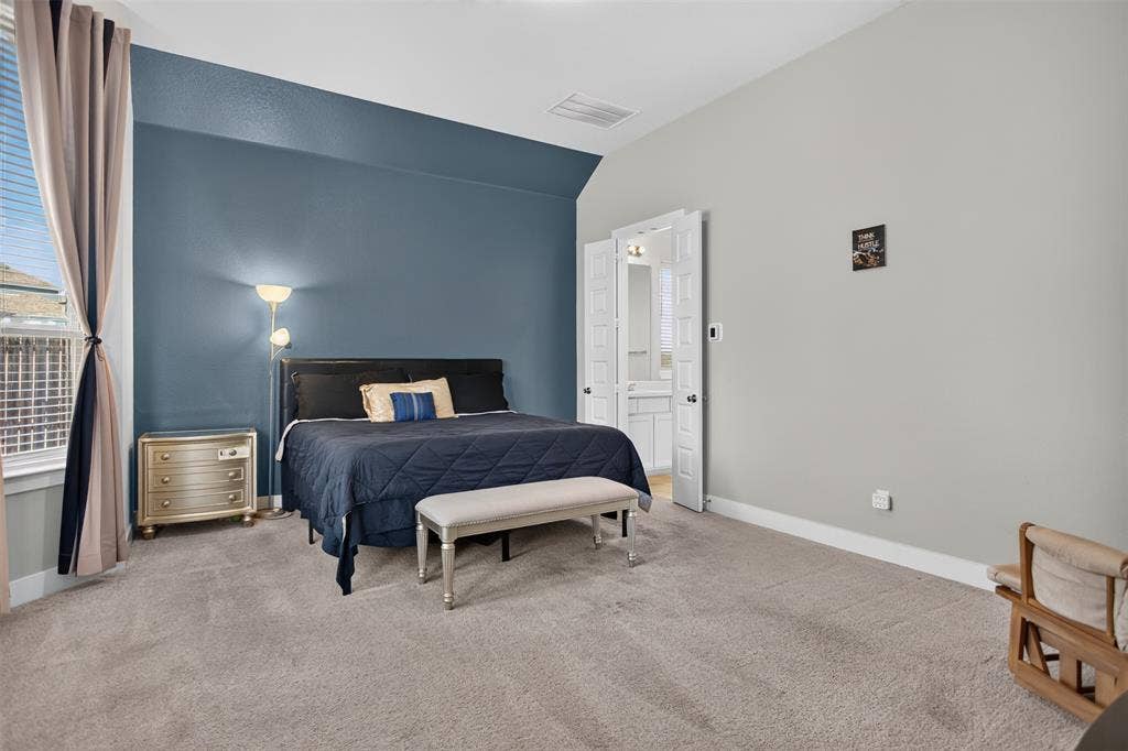 1103 Walford Drive, Forney, TX 75126 Spacious room featuring neutral carpeting, a dual-tone wall treatment with a bold accent wall, double-door entry, and window with tiered drapery