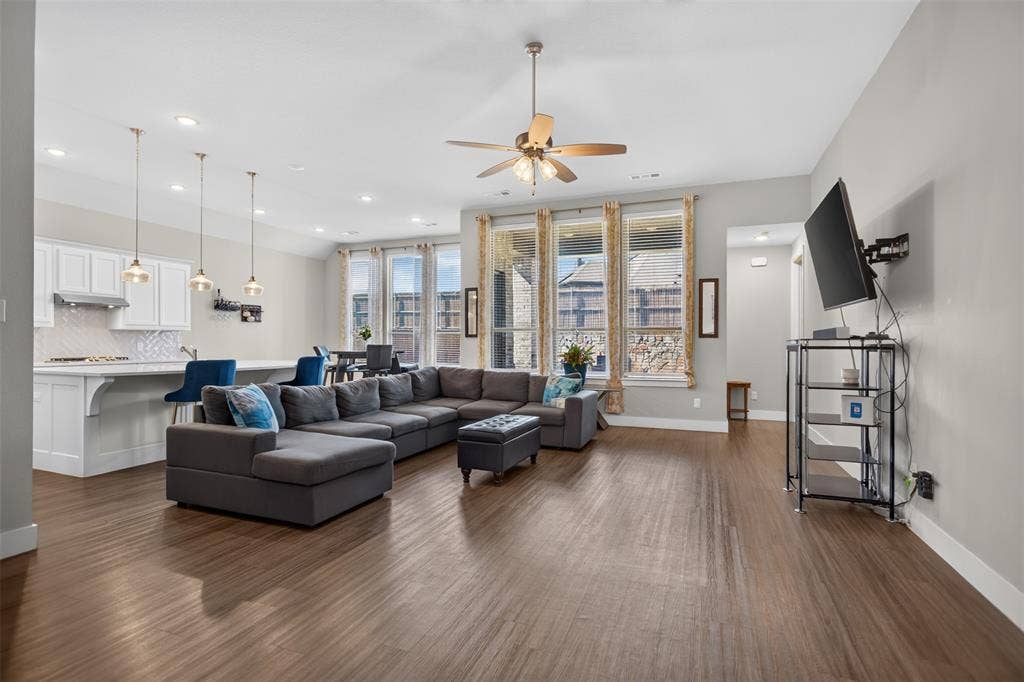 1103 Walford Drive, Forney, TX 75126 Open concept interior featuring wood-finish flooring, recessed lighting, white cabinetry, a center island with pendant fixtures, and tall windows