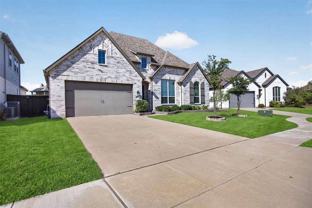 1103 Walford Drive, Forney, TX 75126 Stone and brick veneer exterior with a concrete driveway, multi-gabled roofline, and arched window detailing