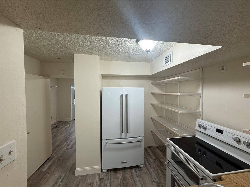 Kitchen with newer white KitchenAid appliances opens to Living Room with Bar seating