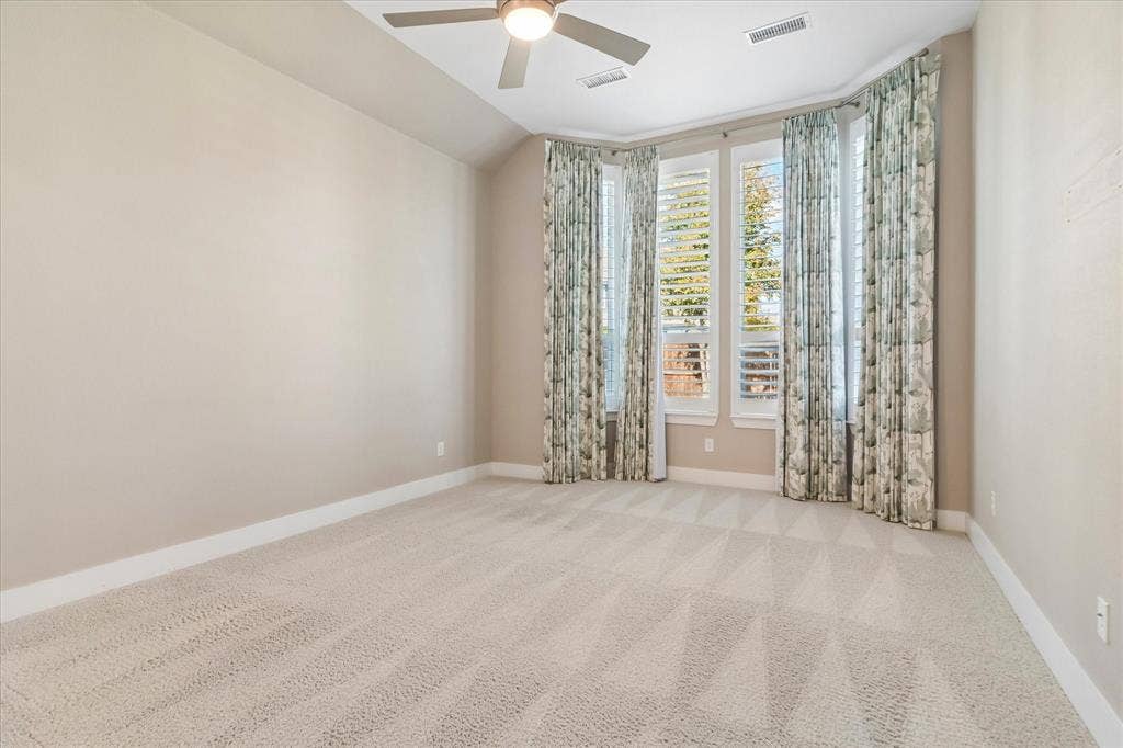 Vaulted ceilings with a central fan, bay window configuration, and shutter-style window coverings