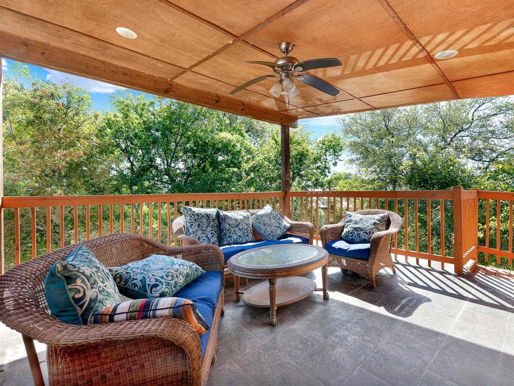 Covered balcony featuring a wood-paneled ceiling, recessed lighting, a ceiling fan, tiled flooring, and wooden railings