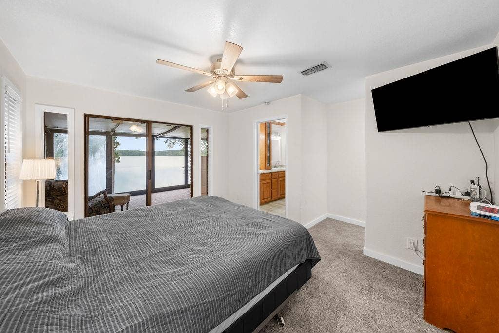 15993 Big Oak Bay Road, Tyler, TX 75707 Interior space featuring neutral wall tones, carpeted flooring, a ceiling fan with integrated lighting, and glass sliding doors