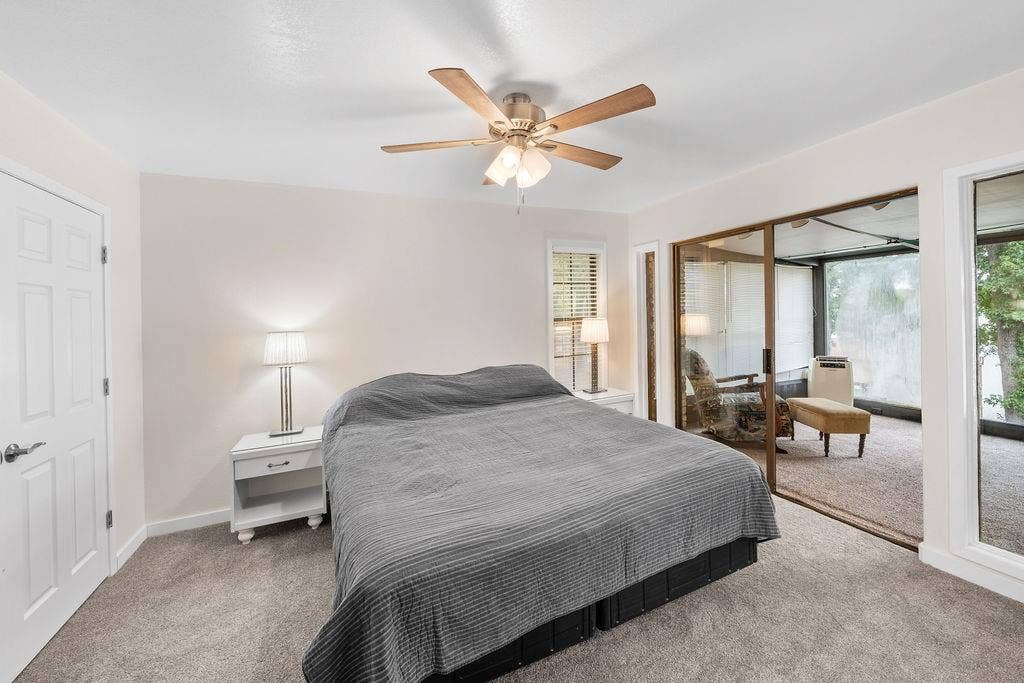 15993 Big Oak Bay Road, Tyler, TX 75707 Neutral interior featuring a ceiling fan with integrated lighting, wall-to-wall carpeting, a six-panel door, and sliding glass doors