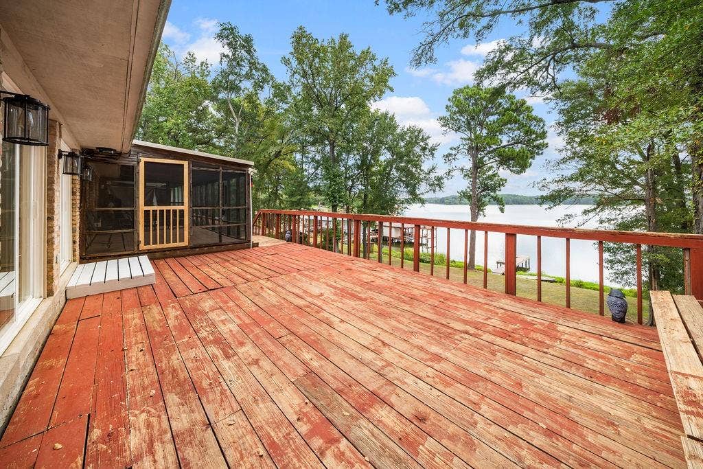 15993 Big Oak Bay Road, Tyler, TX 75707 Expansive wood deck featuring a screened-in porch, built-in wooden bench, and water frontage