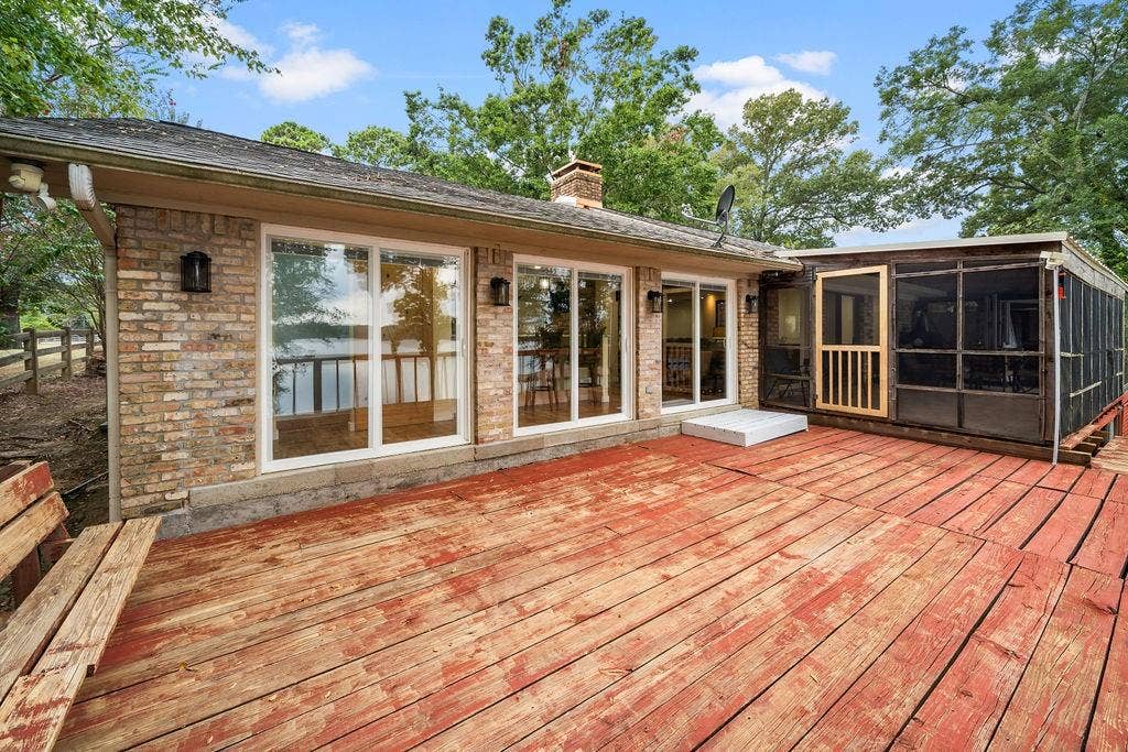 15993 Big Oak Bay Road, Tyler, TX 75707 Exterior featuring brick facade, expansive wood deck, attached screened-in porch, and sliding glass door entries