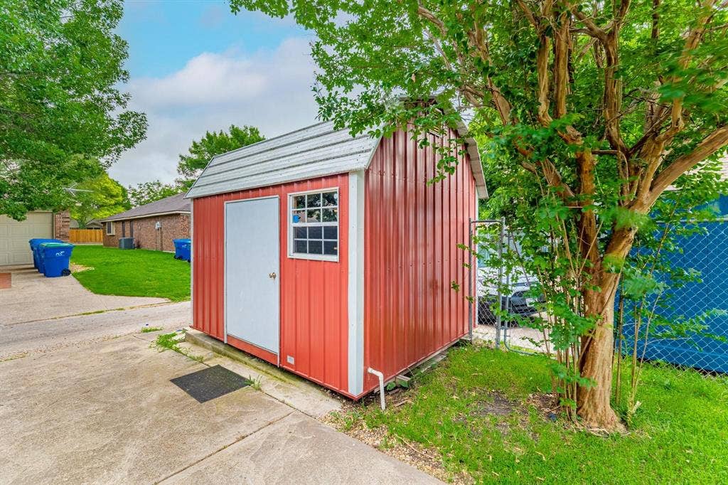 3618 Flagstone Avenue, Rowlett, TX 75088 Metal storage structure featuring a barn-style roof, single-door entry, and a side window