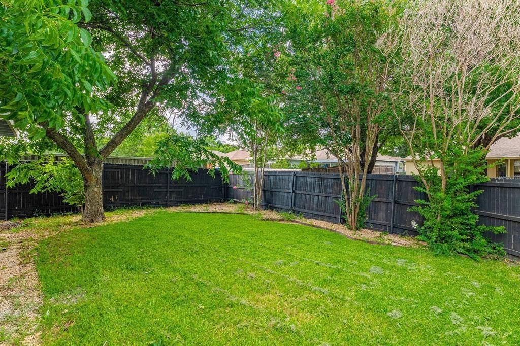 3618 Flagstone Avenue, Rowlett, TX 75088 Fenced backyard featuring established shade trees, a grass lawn, and mature ornamental plantings