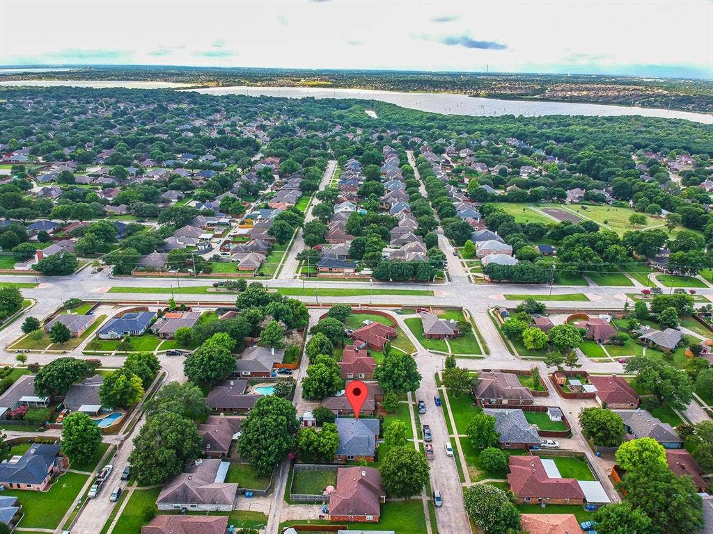 3618 Flagstone Avenue, Rowlett, TX 75088 Aerial perspective featuring a residential lot with mature trees and proximity to a large body of water