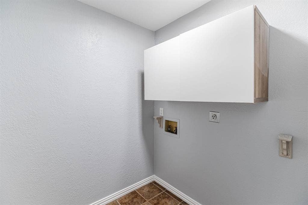 3618 Flagstone Avenue, Rowlett, TX 75088 Wall-mounted cabinetry featuring a white finish with wood-tone side detailing and ceramic tile flooring