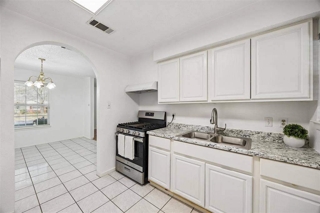 Light and bright white kitchen open to dining area.