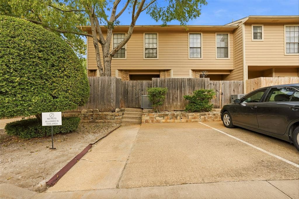 14333 Preston Road, #806, Dallas, TX 75254 Two-story residence with horizontal siding, dedicated paved parking, stone retaining wall, and wood privacy fencing