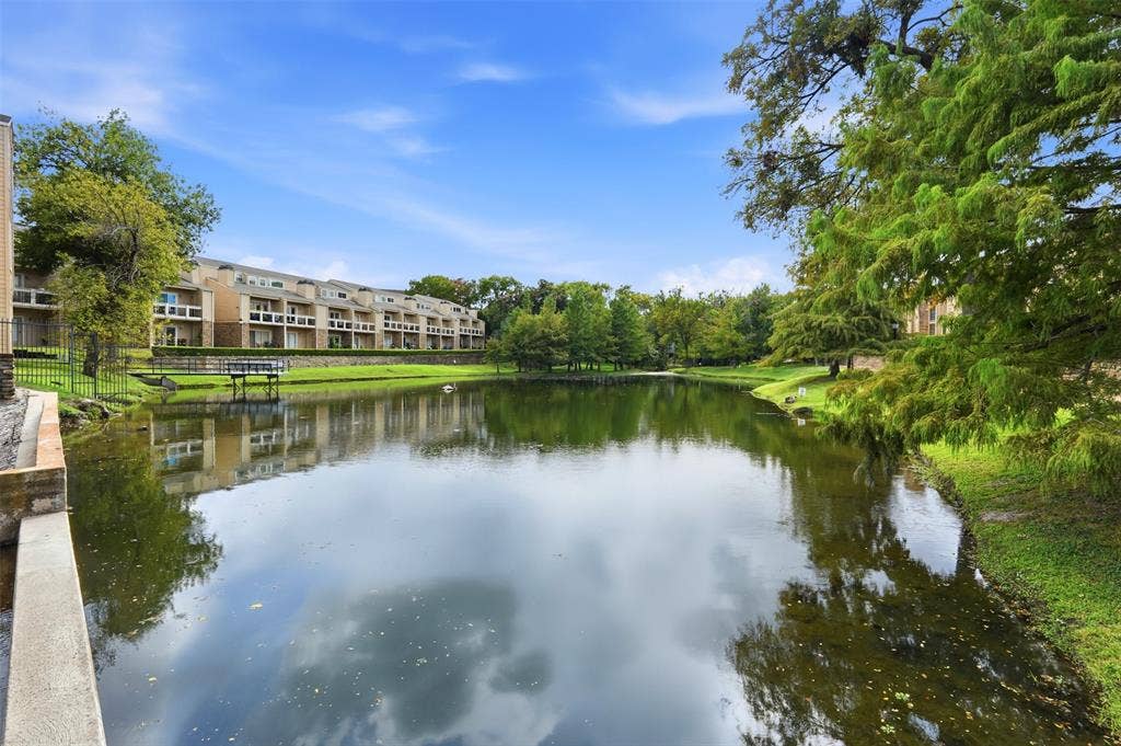 14333 Preston Road, #806, Dallas, TX 75254 Waterfront pond featuring grassy banks, stone retaining wall, and mature trees