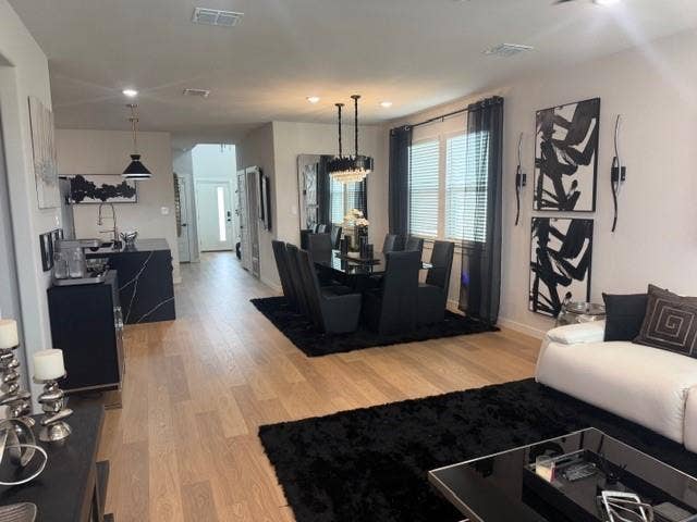 2416 Adenmore Lane, Forney, TX 75126 Open-concept living space featuring wood-finish flooring, recessed lighting, and a kitchen island with a stone-finish countertop