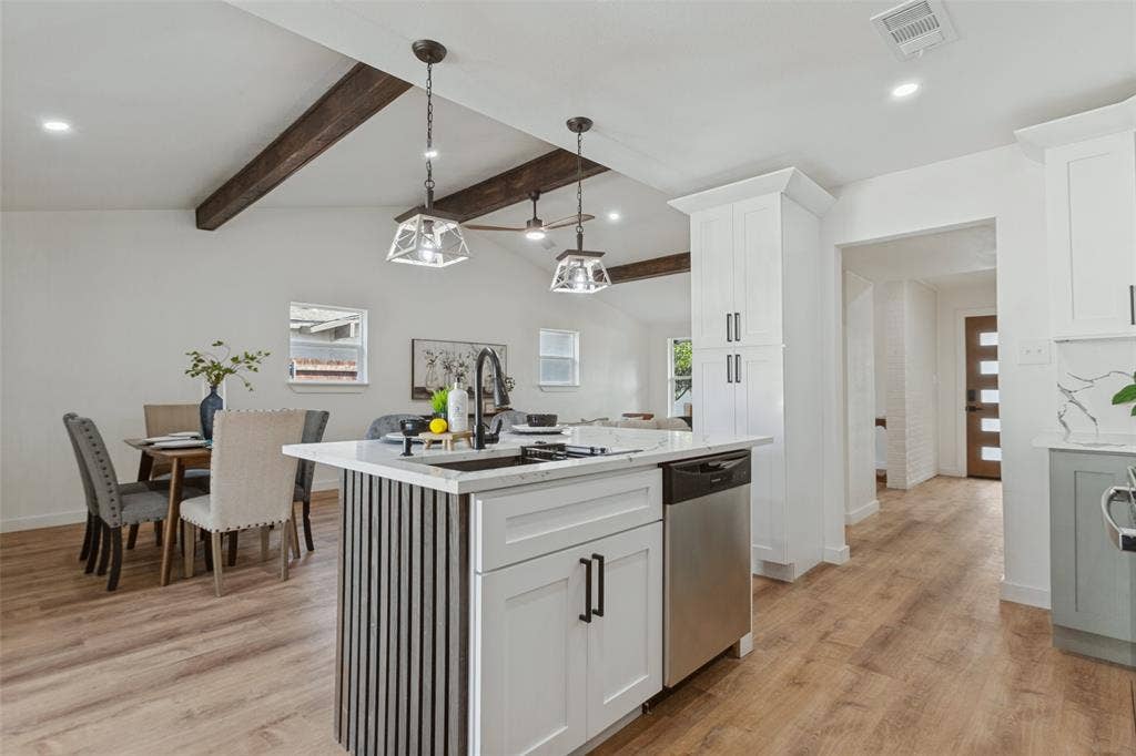 828 Melrose Drive, Richardson, TX 75234 Kitchen island with a slatted base, white cabinetry, wood-finish flooring, exposed ceiling beams, and pendant lighting