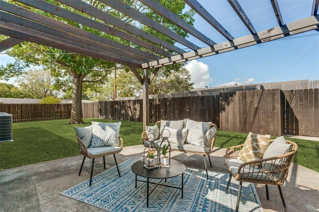 828 Melrose Drive, Richardson, TX 75234 Backyard featuring a concrete patio, a wooden pergola, a manicured lawn, and perimeter wood fencing